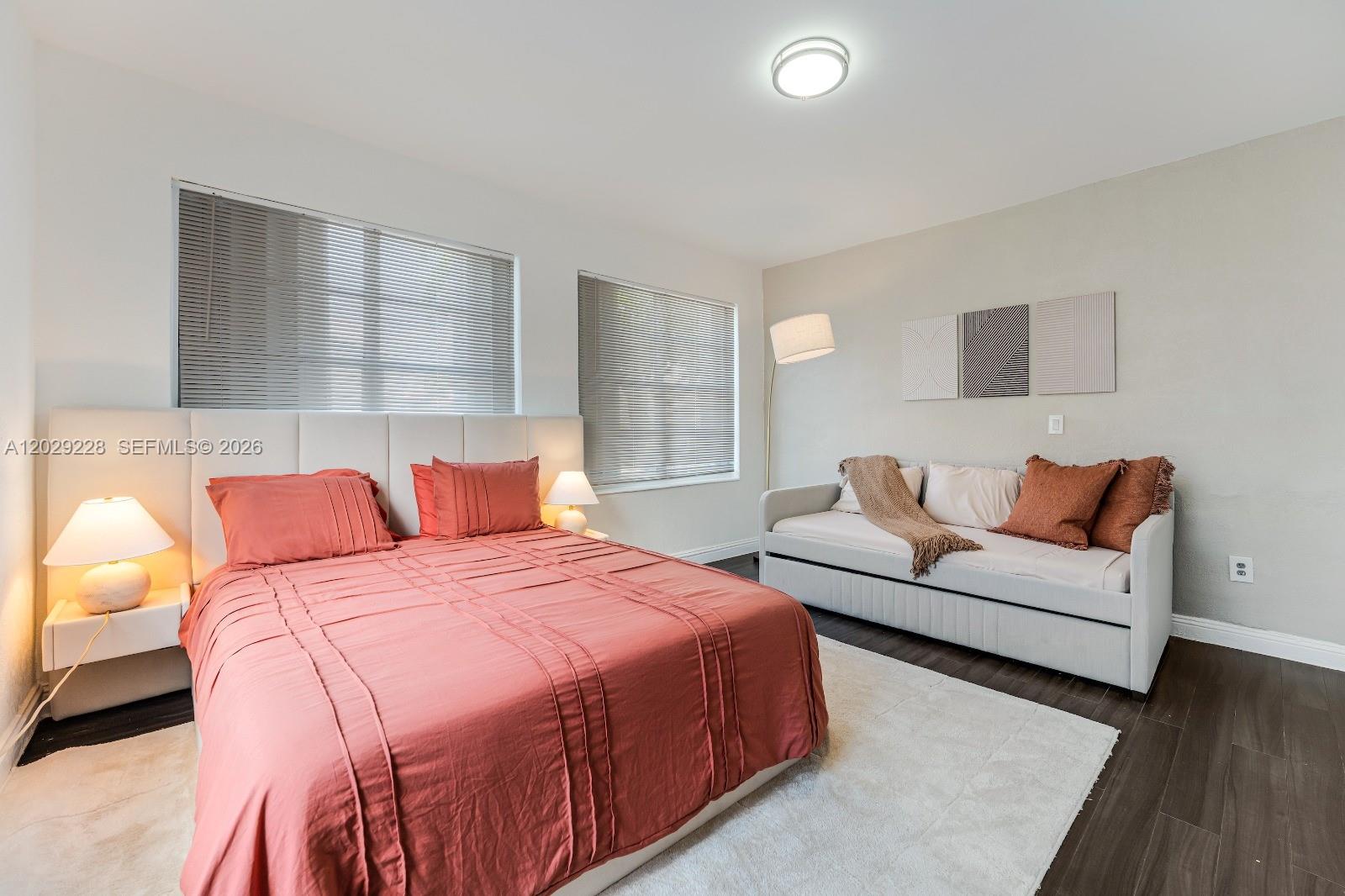A bedroom features a bed with a coral comforter, a daybed, and light-colored flooring — 301 SW 10th Ave # 2, Miami FL 33130, MIAMI, FL