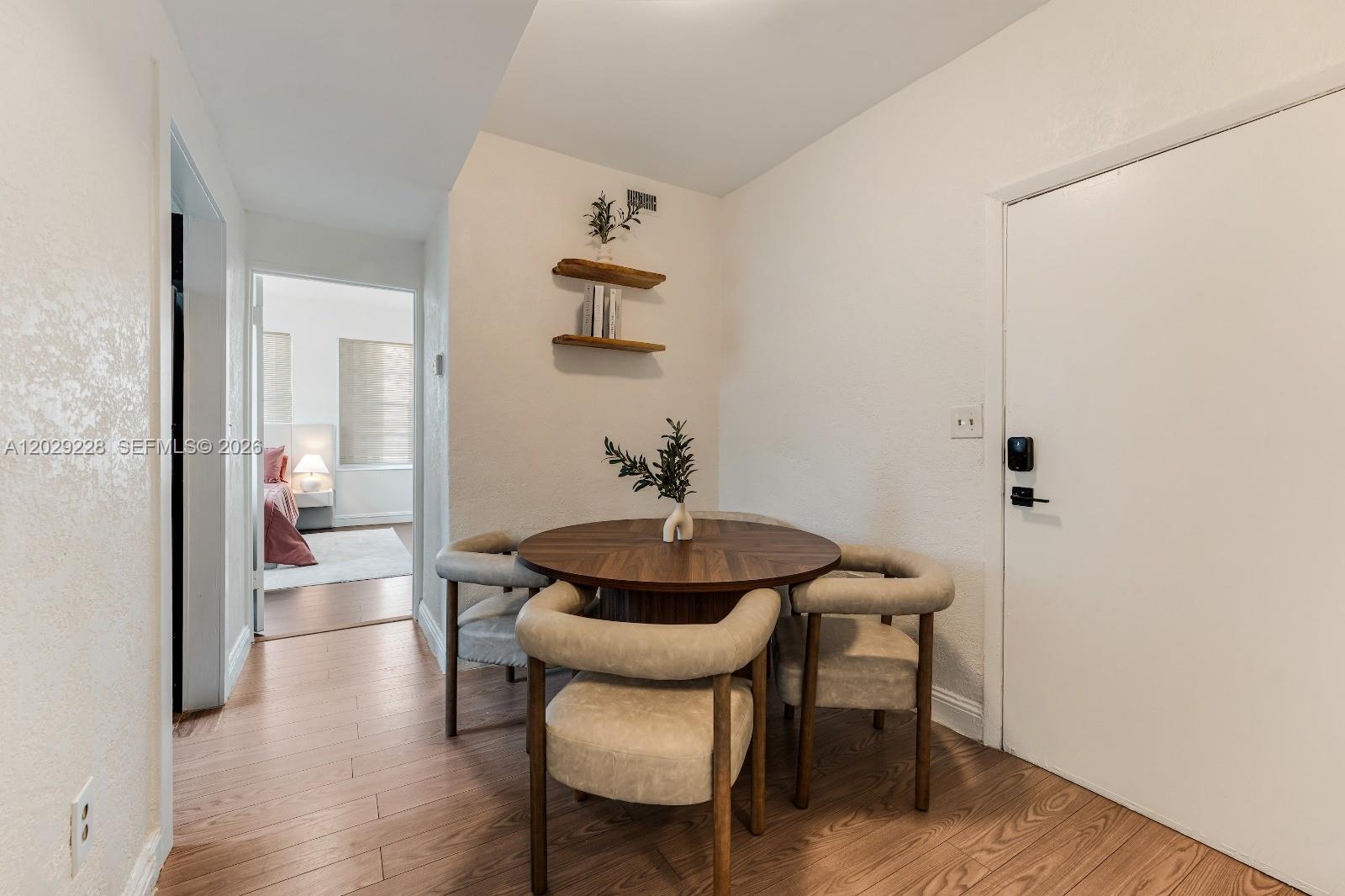 A small dining area features a round wooden table, four chairs, and wall-mounted shelves — 301 SW 10th Ave # 2, Miami FL 33130, MIAMI, FL
