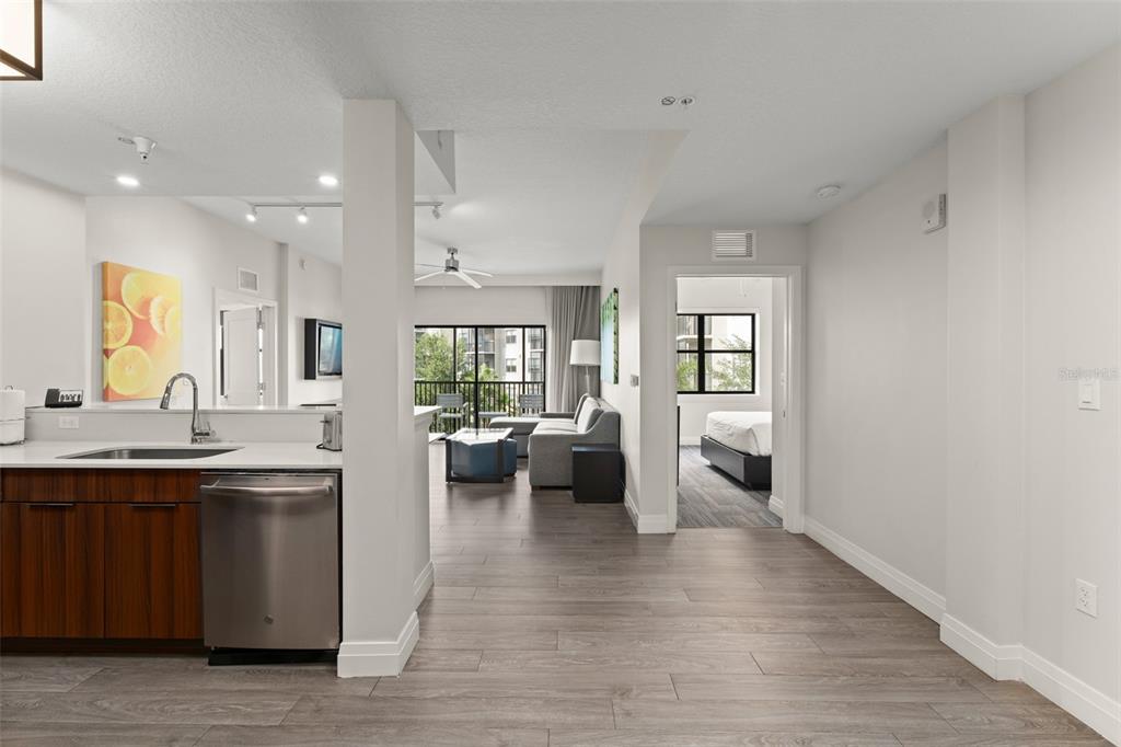 A kitchen with stainless steel appliances overlooks a living area with a balcony and bedroom — 14501 GROVE RESORT AVENUE UNIT 2334, WINTER GARDEN, FL