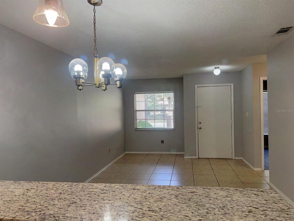 A dining area with tile flooring, a chandelier, and a white front door — 1421 SOPHIE BOULEVARD, ORLANDO, FL