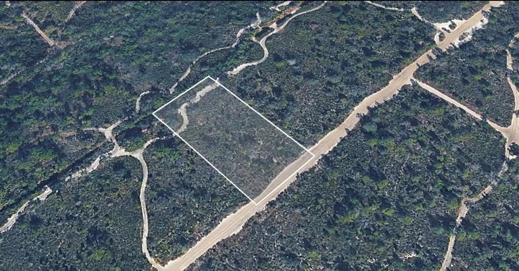 An aerial view shows a rectangular plot of land outlined in white along a road — UNASSIGNED, LAKE WALES, FL