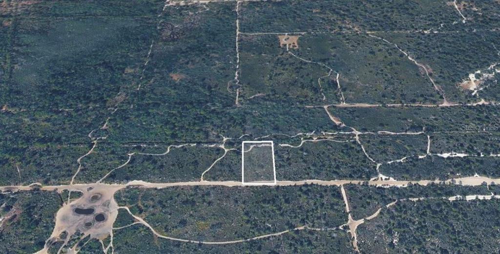 An aerial view shows a rectangular plot of land outlined in white amidst rural vegetation — UNASSIGNED, LAKE WALES, FL