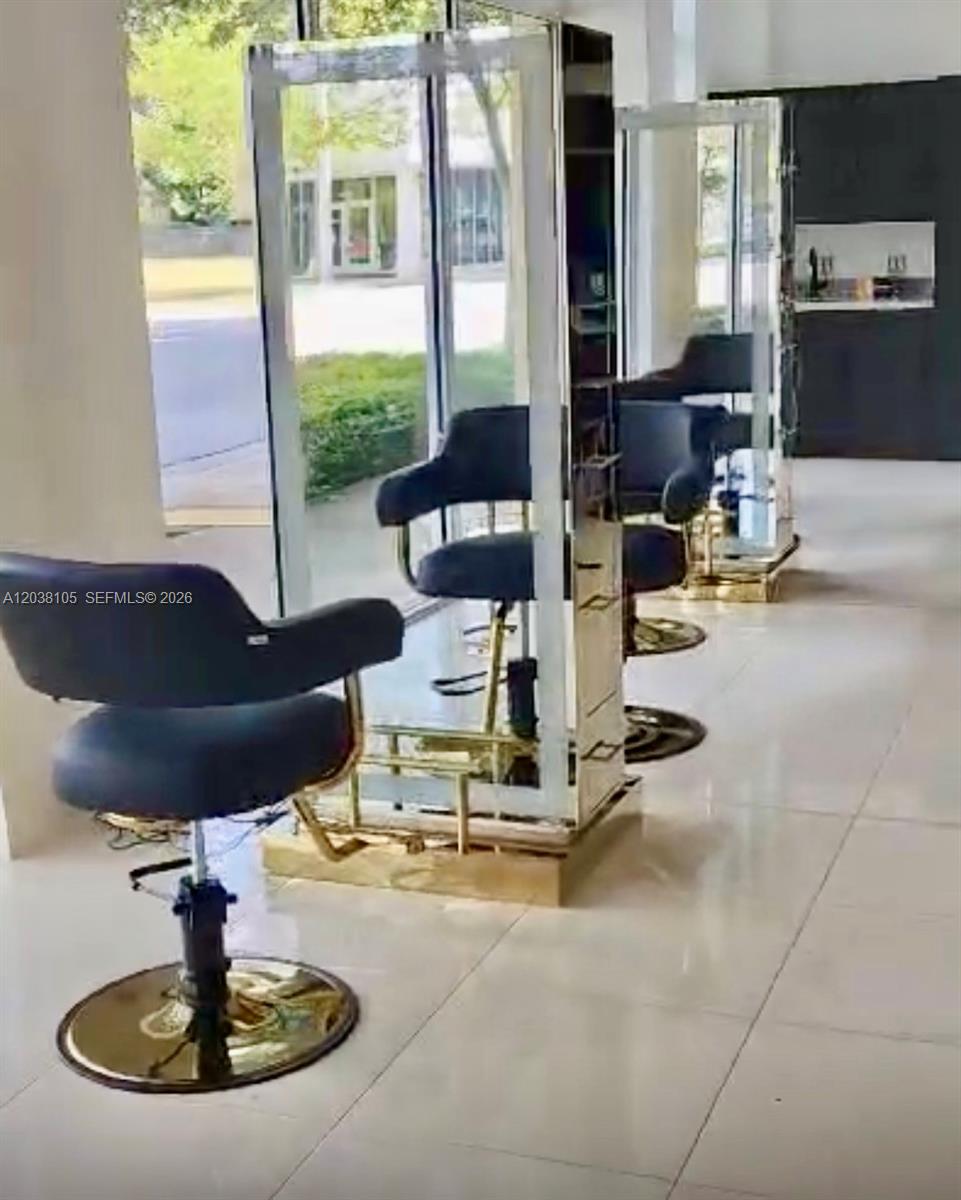 A salon interior features several black chairs positioned in front of mirrored styling stations — CORAL GABLES, FL