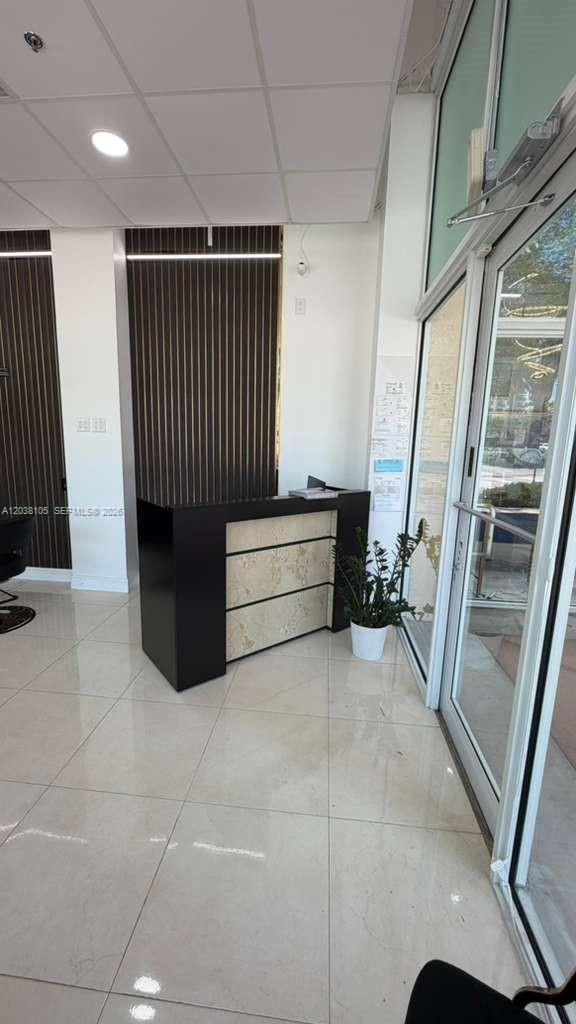 A reception desk with a marble-patterned front sits in a room with tiled floors — CORAL GABLES, FL