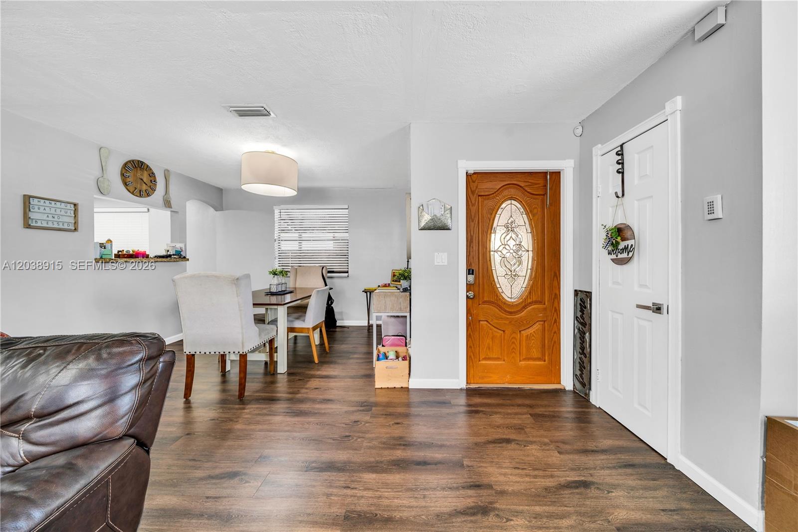 An interior view shows a dining area and entryway with wood-look flooring and light walls — 875 E 29th St # 1, Hialeah FL 33013, HIALEAH, FL