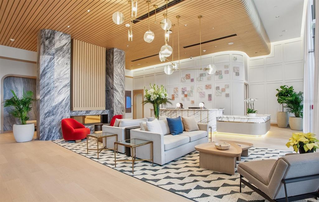 A modern lobby features a white sofa, marble reception desk, and a large gold chandelier — 3015 S YSABELLA AVENUE UNIT 603, TAMPA, FL