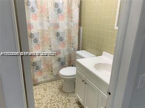 A bathroom features a white vanity, a toilet, and a shower with a nautical-themed curtain — 4655 Palm Ave # 315, Hialeah FL 33012, HIALEAH, FL