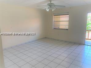 An empty room with white tiled floors, beige walls, a ceiling fan, and a window — 4655 Palm Ave # 315, Hialeah FL 33012, HIALEAH, FL