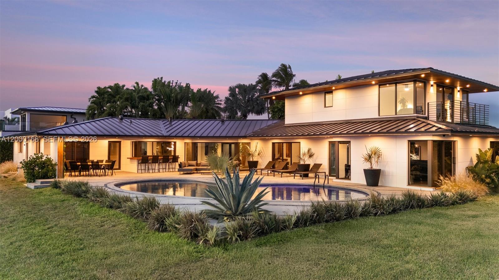 A two-story modern house features a swimming pool, patio seating, and a metal roof — 1982 NE 119th Rd, North Miami FL 33181, NORTH MIAMI, FL