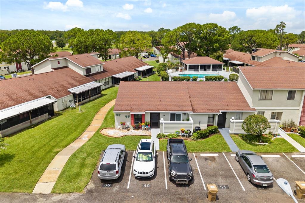 An aerial view shows a residential building with a brown roof and parking spaces — 49 PINE ISLAND CIRCLE, KISSIMMEE, FL