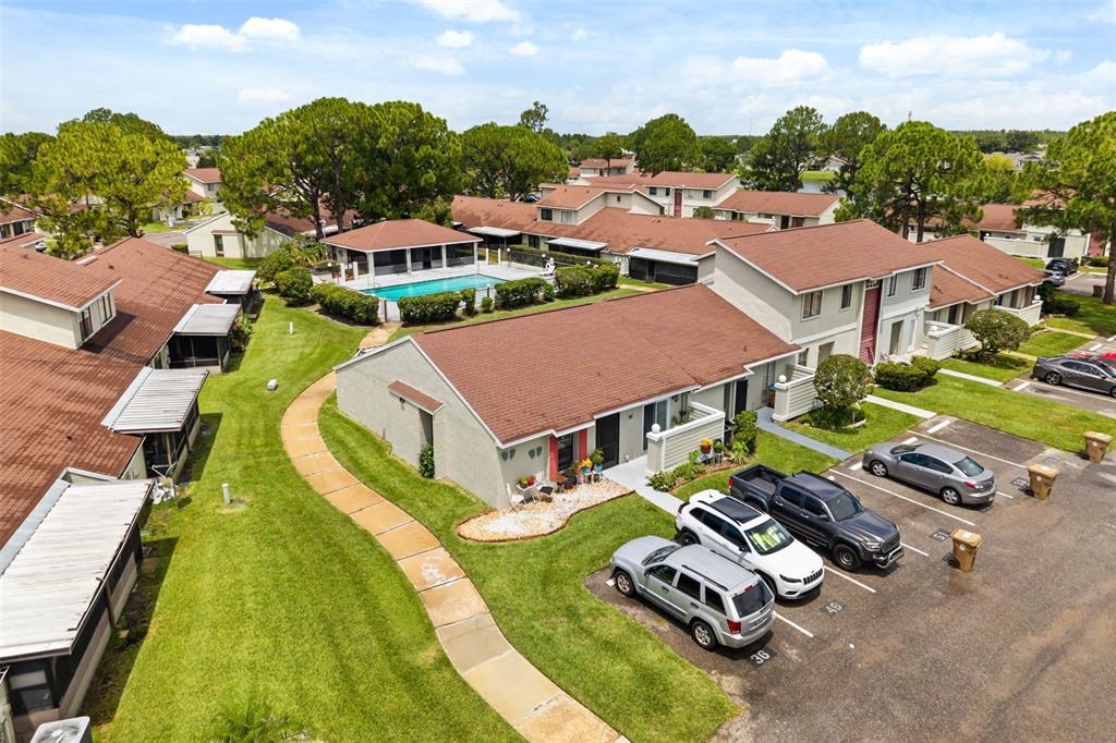 An aerial view shows a residential complex with a swimming pool and parking spaces — 49 PINE ISLAND CIRCLE, KISSIMMEE, FL