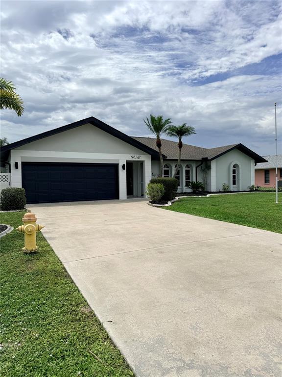 A bright, empty room features white tiled floors, recessed lighting, and a vaulted ceiling — 167 MOCHA COURT, PUNTA GORDA, FL