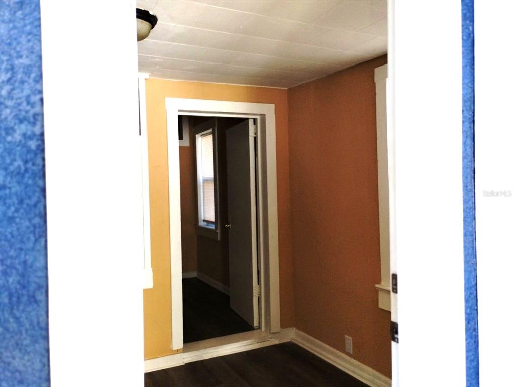 A view through a doorway into a room with orange walls and dark wood flooring — 418 E AMELIA AVENUE UNIT D, TAMPA, FL