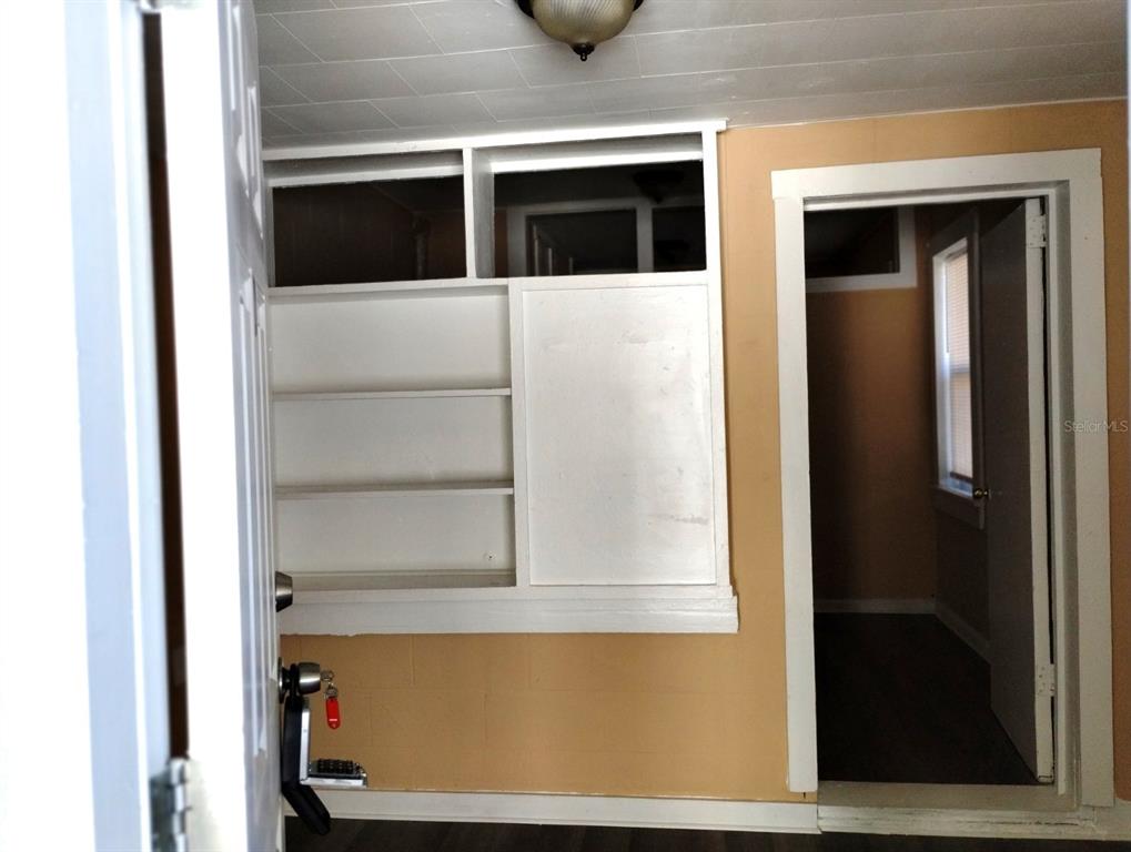 A room features tan walls, white built-in shelving, and a doorway leading to another space — 418 E AMELIA AVENUE UNIT D, TAMPA, FL