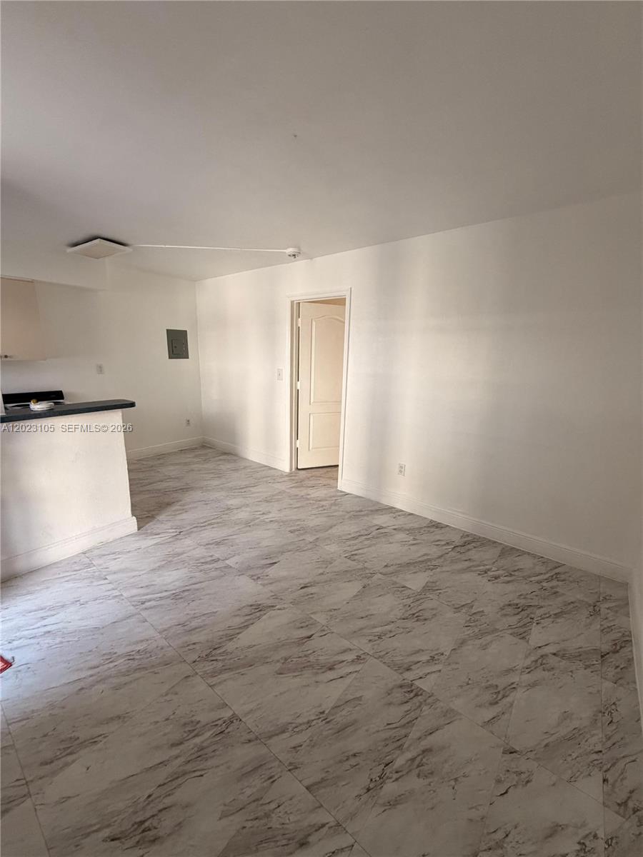 An empty room features white walls, a doorway, and light-colored marble-patterned tile flooring — 154 W 26th St # 2, Hialeah FL 33010, HIALEAH, FL