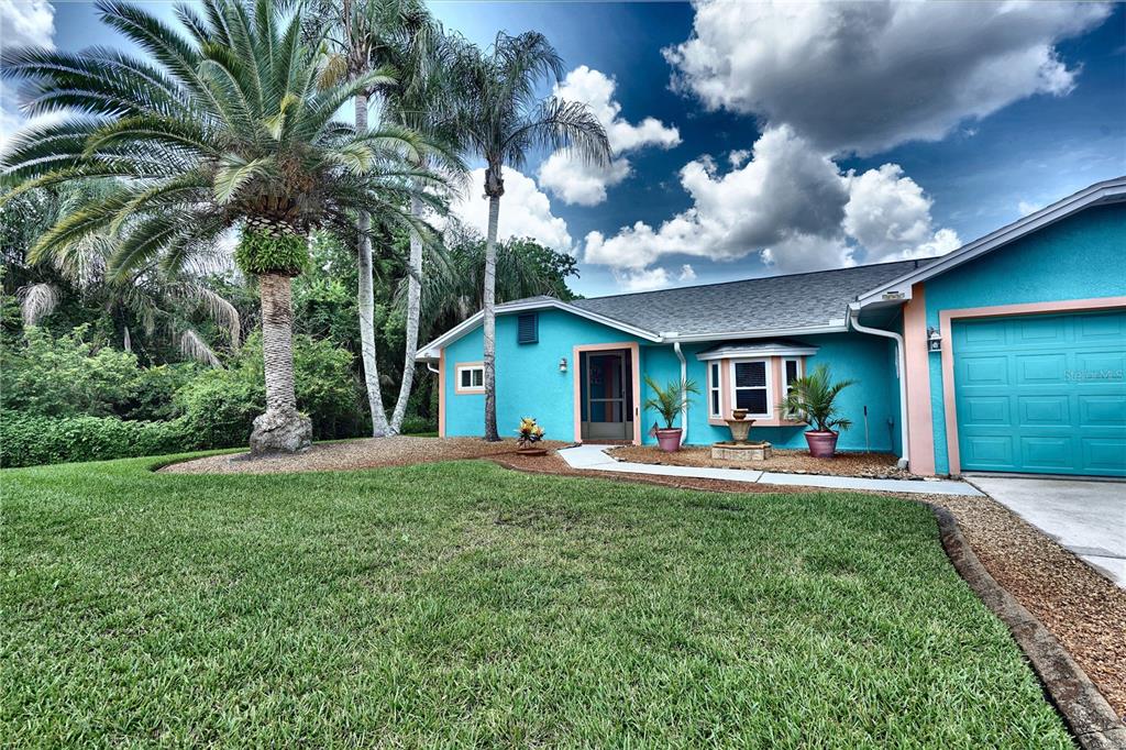 A bright blue house with a palm tree, a front lawn, and a garage — 2724 ABBEY AVENUE, ORLANDO, FL