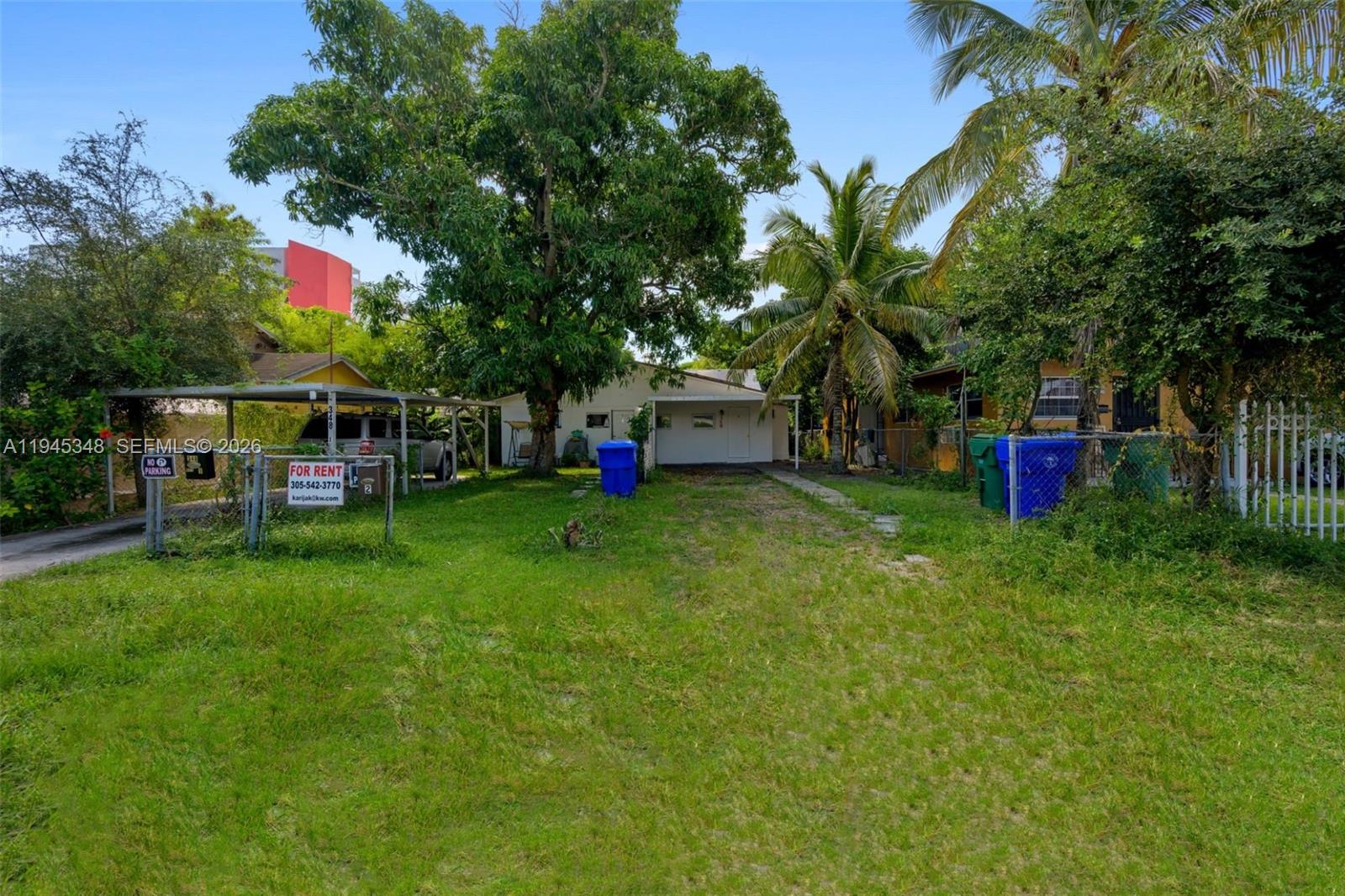 A single-story house with a carport and a large grassy yard under mature trees — 348 NE 58th St, Miami FL 33137, MIAMI, FL