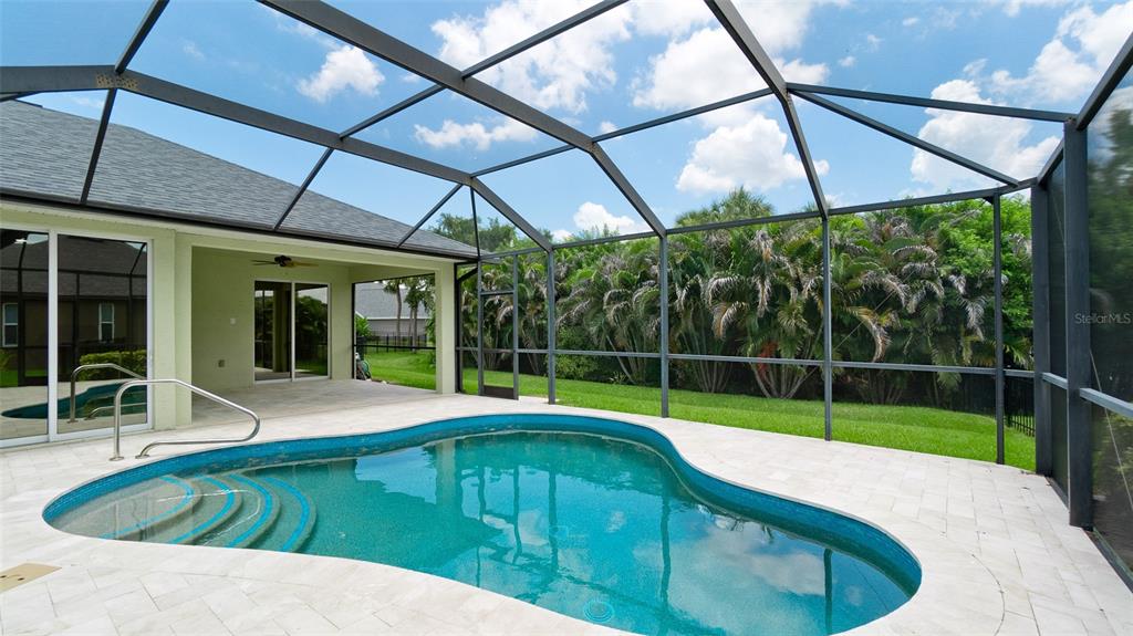 A screened-in patio features a kidney-shaped swimming pool and a covered seating area — 5323 90TH AVENUE CIRCLE E, PARRISH, FL