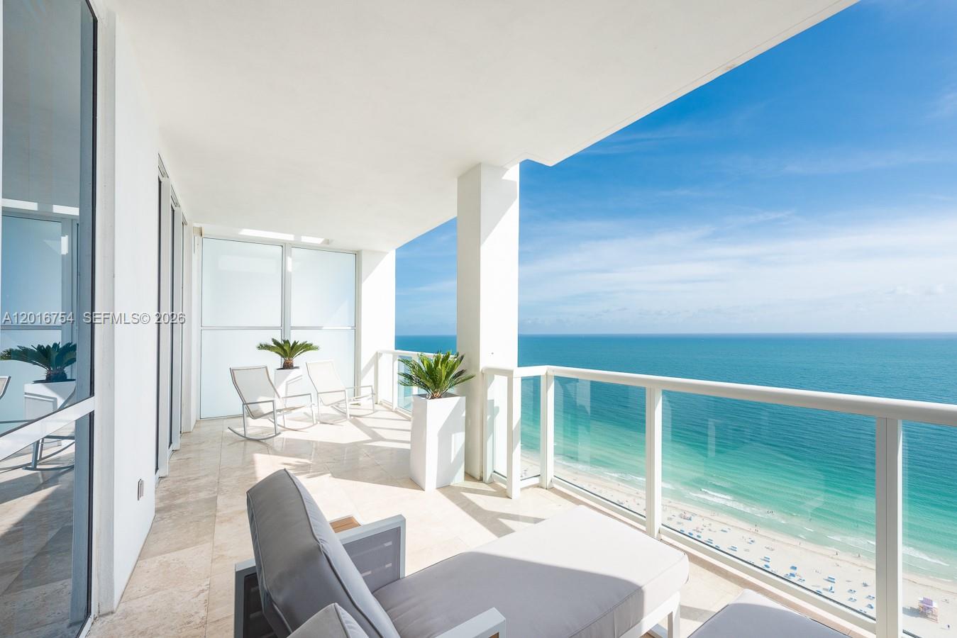 A high-rise balcony features tile flooring, outdoor furniture, and a panoramic view of the ocean — 50 S Pointe Dr # 3302, Miami Beach FL 33139, MIAMI BEACH, FL