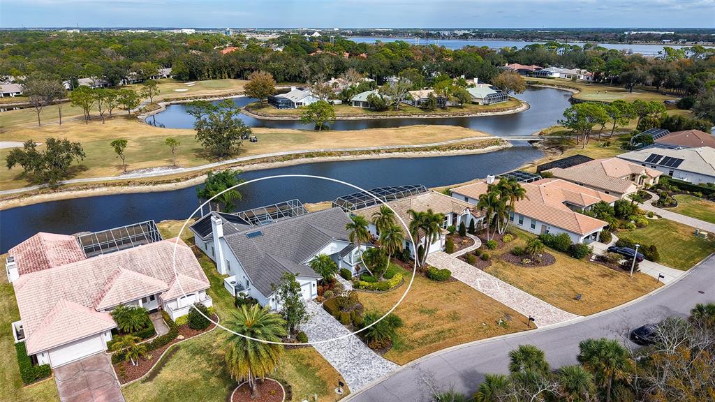 An aerial view shows a single-story house with a screened pool enclosure and tiled roof — 5515 DOWNHAM MEADOWS, SARASOTA, FL
