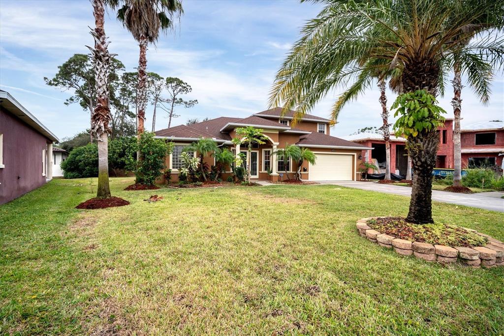A tan two-story house with a brown roof and palm trees in the front yard — 2780 BETHEL COURT S, ST PETERSBURG, FL