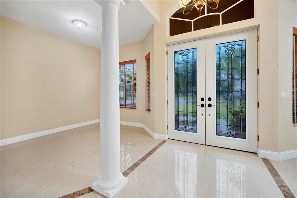 An entryway with a white column, tile flooring, and double doors with decorative glass inserts — 2780 BETHEL COURT S, ST PETERSBURG, FL