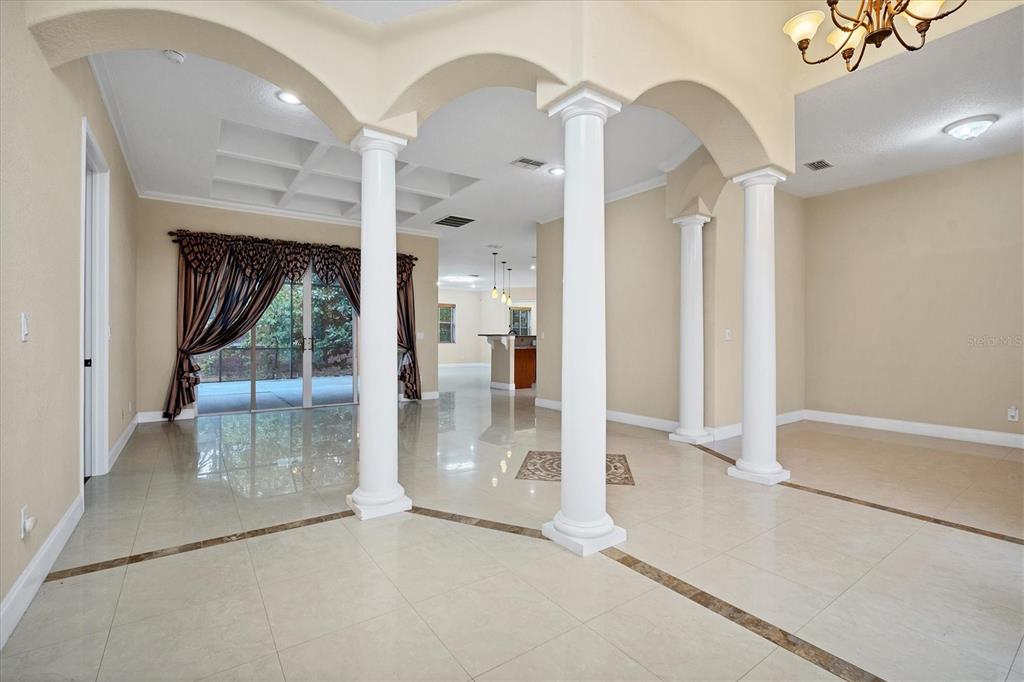 An open living area features white columns, arched entryways, and light-colored tile flooring — 2780 BETHEL COURT S, ST PETERSBURG, FL