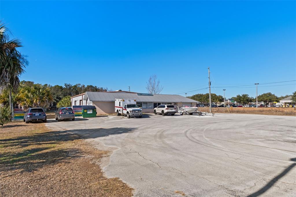 A single-story commercial building with a metal roof sits behind a large paved parking lot — 6680 W GULF TO LAKE HIGHWAY, CRYSTAL RIVER, FL