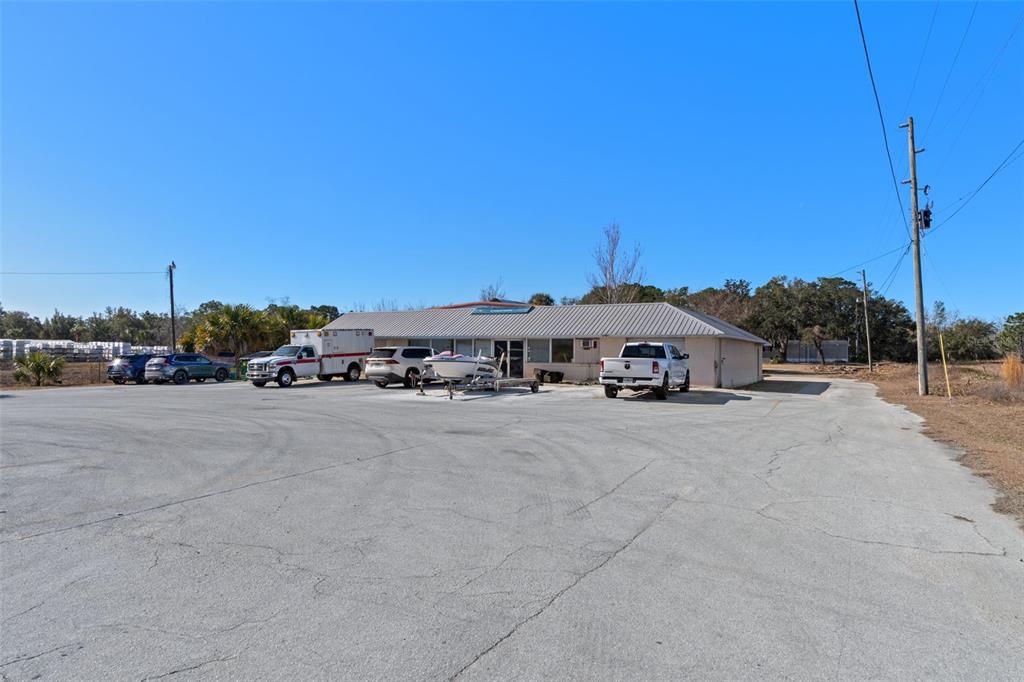 A single-story commercial building with a parking lot containing several vehicles and a boat — 6680 W GULF TO LAKE HIGHWAY, CRYSTAL RIVER, FL