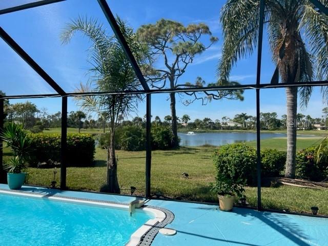 A view from a screened-in pool deck overlooking a pond and golf course — 2091 KING TARPON DRIVE, PUNTA GORDA, FL
