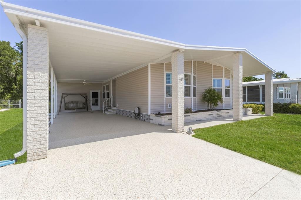 A single-story house with beige siding, a large carport, and a concrete driveway — 209 VISTORIA DRIVE, NORTH PORT, FL