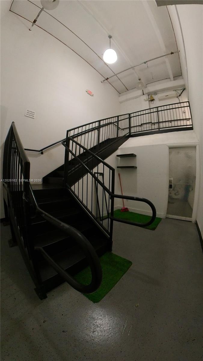 A staircase with black metal railings leads to an upper landing in a white room — 2746 NW 112th Ave # 2746, Doral FL 33172, DORAL, FL