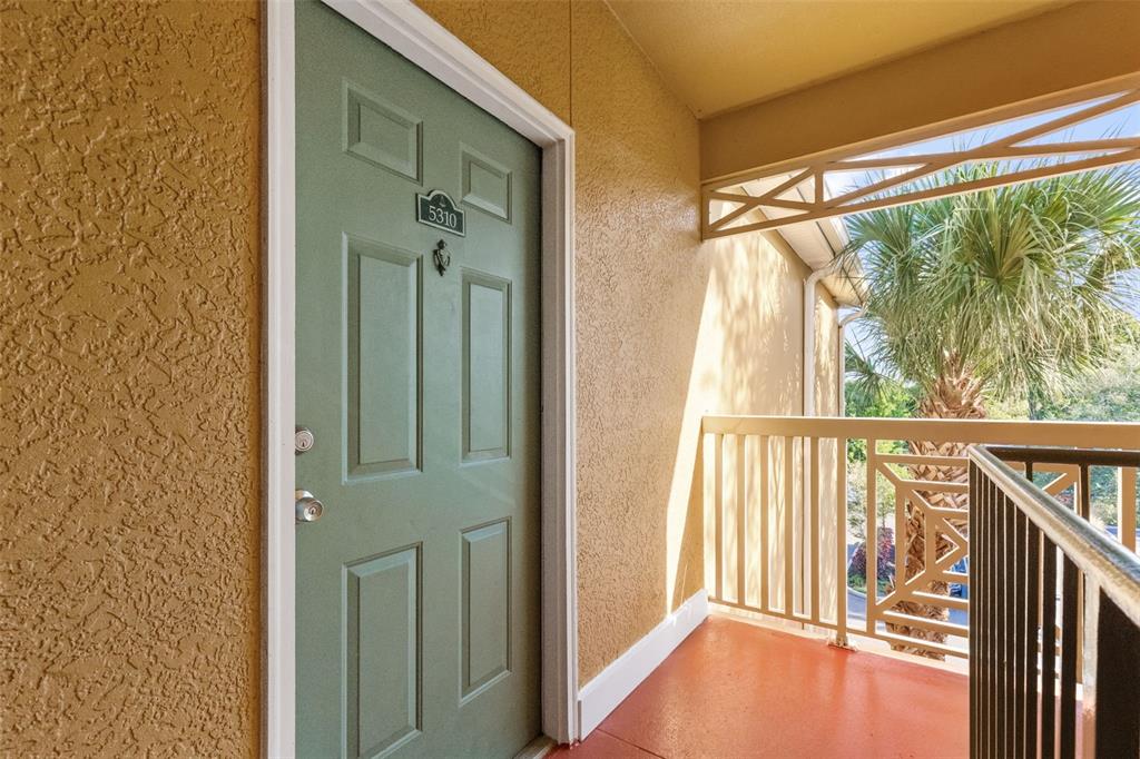 A green front door with the number 5310 sits on an outdoor apartment balcony — 4207 S DALE MABRY HIGHWAY UNIT 5310, TAMPA, FL