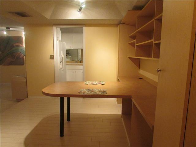 A room features a built-in wooden desk and shelving unit with a light-colored floor — 3660 Inverrary Drive # 2f, Lauderhill FL 33319, LAUDERHILL, FL