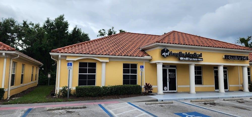 A single-story commercial building with a tiled roof, yellow stucco walls, and two entrance doors — 13045 SUMMERFIELD SQUARE DRIVE, RIVERVIEW, FL