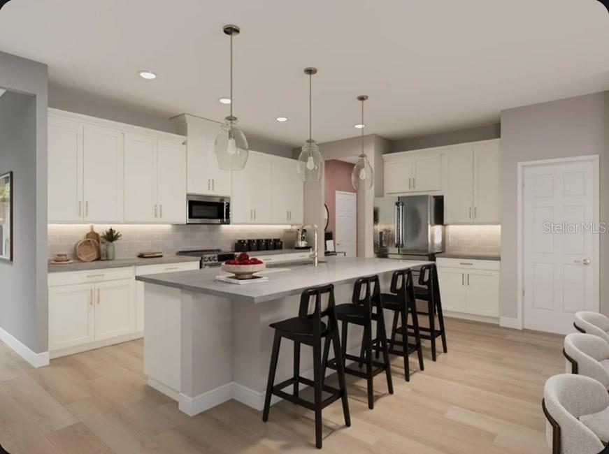 This rendering shows a modern kitchen with white cabinets, a gray island, and black stools — 11341 BOURBON ROSE CIRCLE, WINTER GARDEN, FL