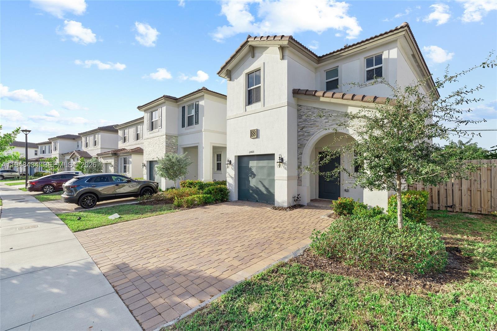 A two-story suburban house with a paved driveway, a garage, and a small front yard — 2405 NW 131st Cir, Miami FL 33167, MIAMI, FL