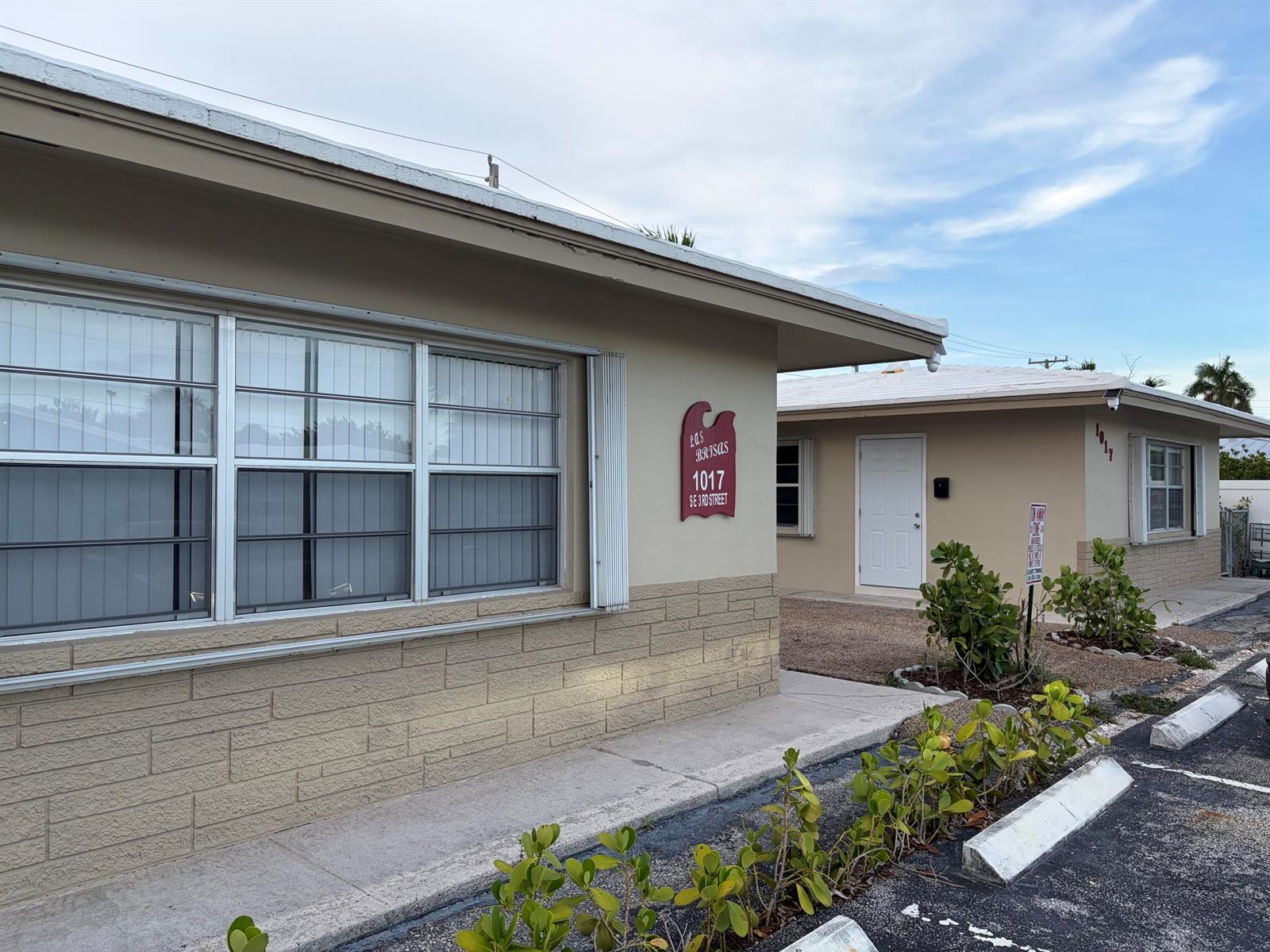 A tan, single-story building with a brick facade and a sign reading Las Brisas — 1017 SE 3rd Street # 4, Deerfield Beach FL 33441, DEERFIELD BEACH, FL