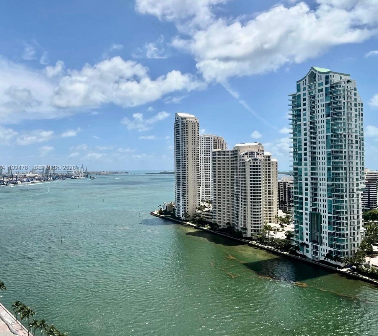An elevated view of high-rise apartment buildings situated along a bay with a blue sky — 300 S Biscayne Blvd # 2012, Miami FL 33131, MIAMI, FL