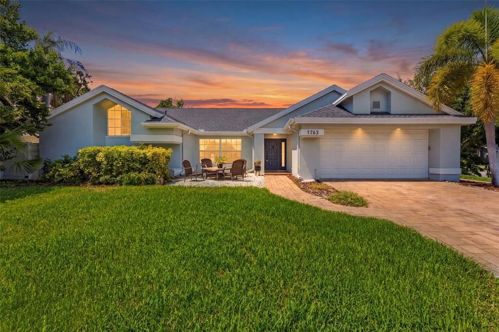 A single-story house with a paved driveway, a front patio, and a two-car garage — 1763 PEBBLE HILL COURT, PALM HARBOR, FL