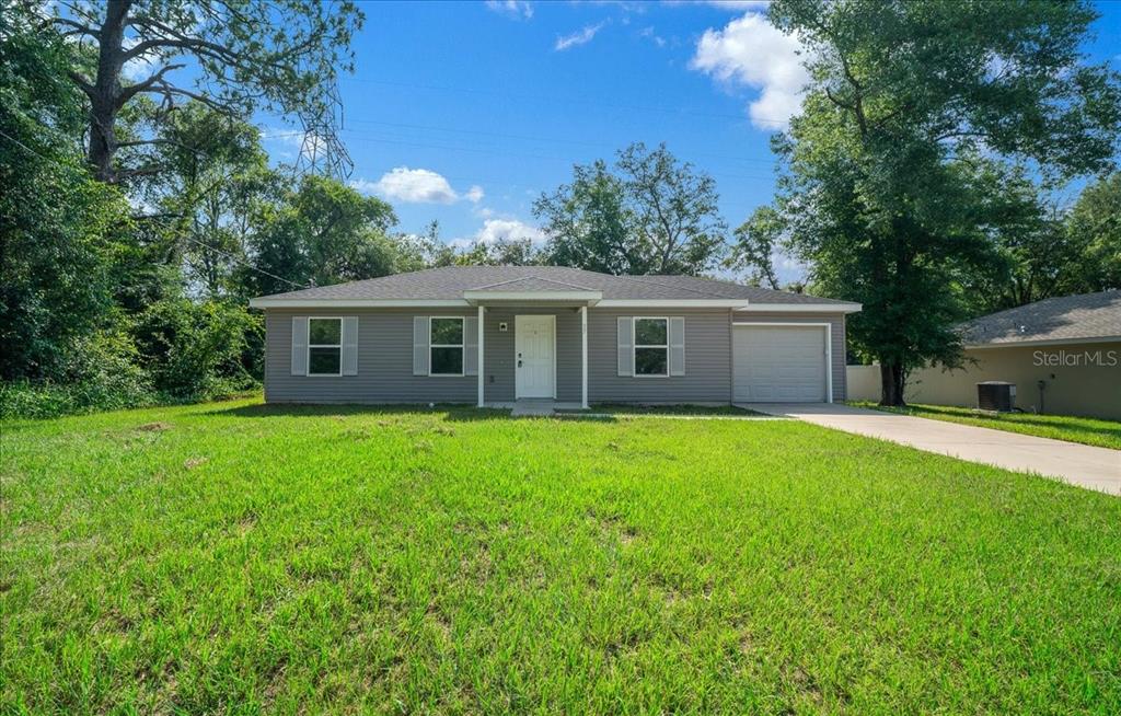 A single-story gray house with a white front door and an attached one-car garage — 37 WATER TRACK COURSE, OCALA, FL