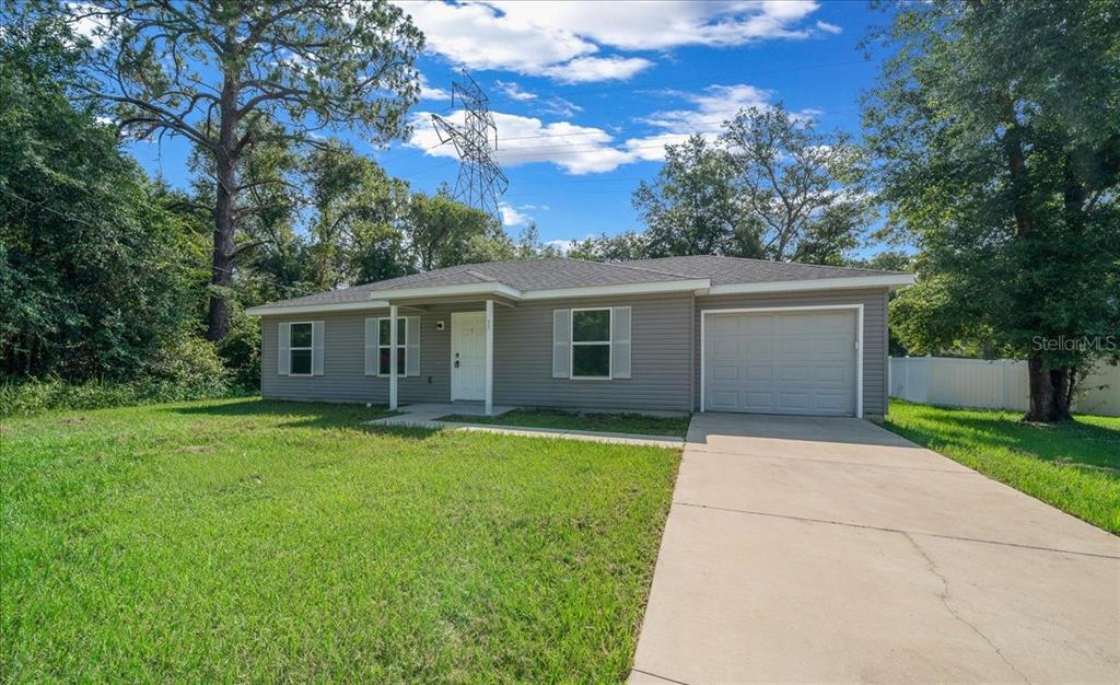A single-story house with gray vinyl siding, a front porch, and an attached garage — 37 WATER TRACK COURSE, OCALA, FL