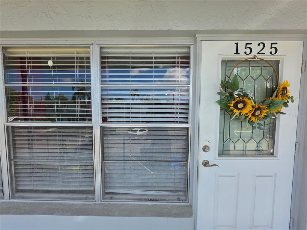A living room features a white sofa, two wicker chairs, and a coffee table — 4325 58TH WAY N UNIT 1525, KENNETH CITY, FL