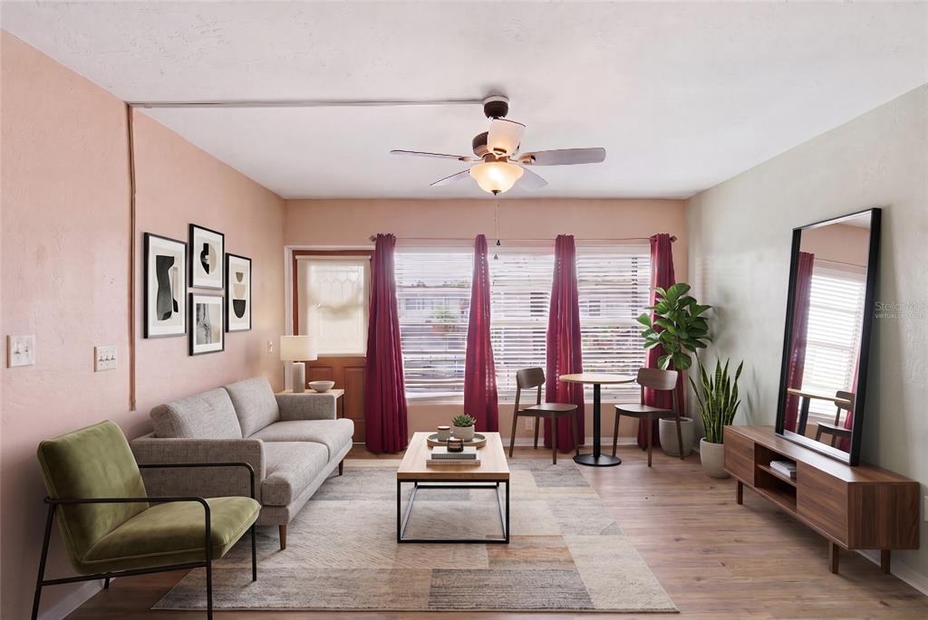 A room with light wood-look flooring, a ceiling fan, and a door leading outside — 4325 58TH WAY N UNIT 1525, KENNETH CITY, FL