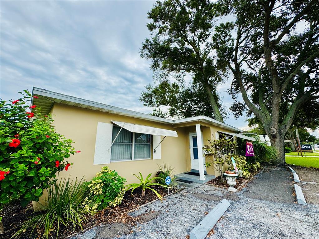 A single-story tan house with a white awning, a front door, and a large tree — 5617 GULFPORT BOULEVARD S, GULFPORT, FL