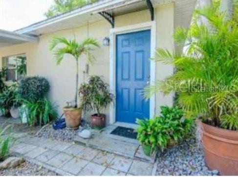 A blue front door is surrounded by potted plants and a stone walkway — 5617 GULFPORT BOULEVARD S, GULFPORT, FL