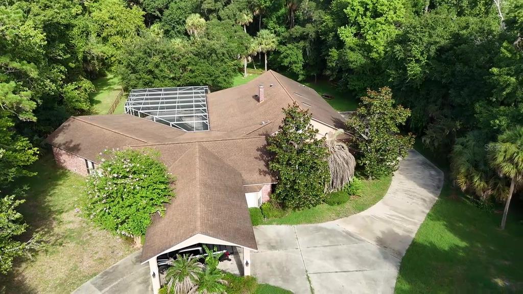 An aerial view of a house with a screened-in pool enclosure and a paved driveway — 2083 BILTMORE POINT, LONGWOOD, FL