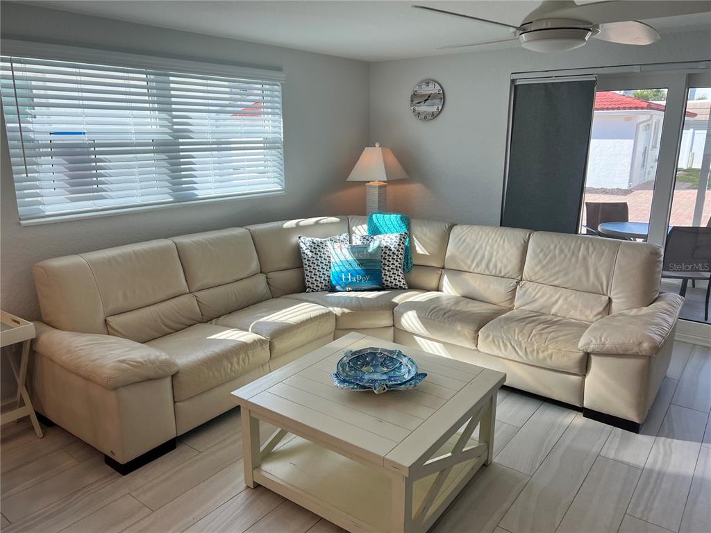 A living room features a large cream sectional sofa, a white coffee table, and tile flooring — 6154 MIDNIGHT PASS ROAD UNIT B02, SARASOTA, FL
