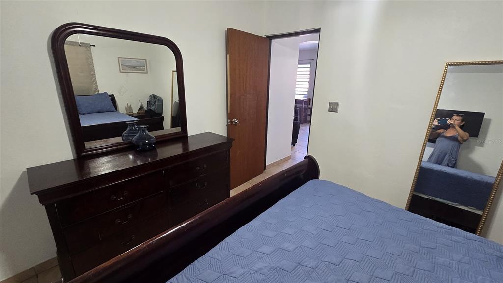A bedroom features a wooden dresser with a mirror, a bed, and a floor mirror — 3 WILLIAM FONT STREET, CULEBRA, PR