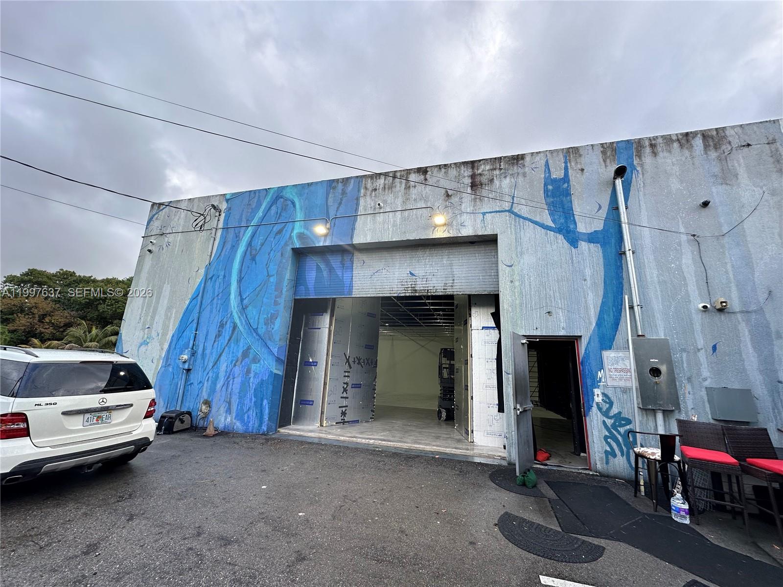 A white SUV is parked in front of a warehouse building with a blue mural — 4151 NW 2nd Ave, Miami FL 33127, MIAMI, FL